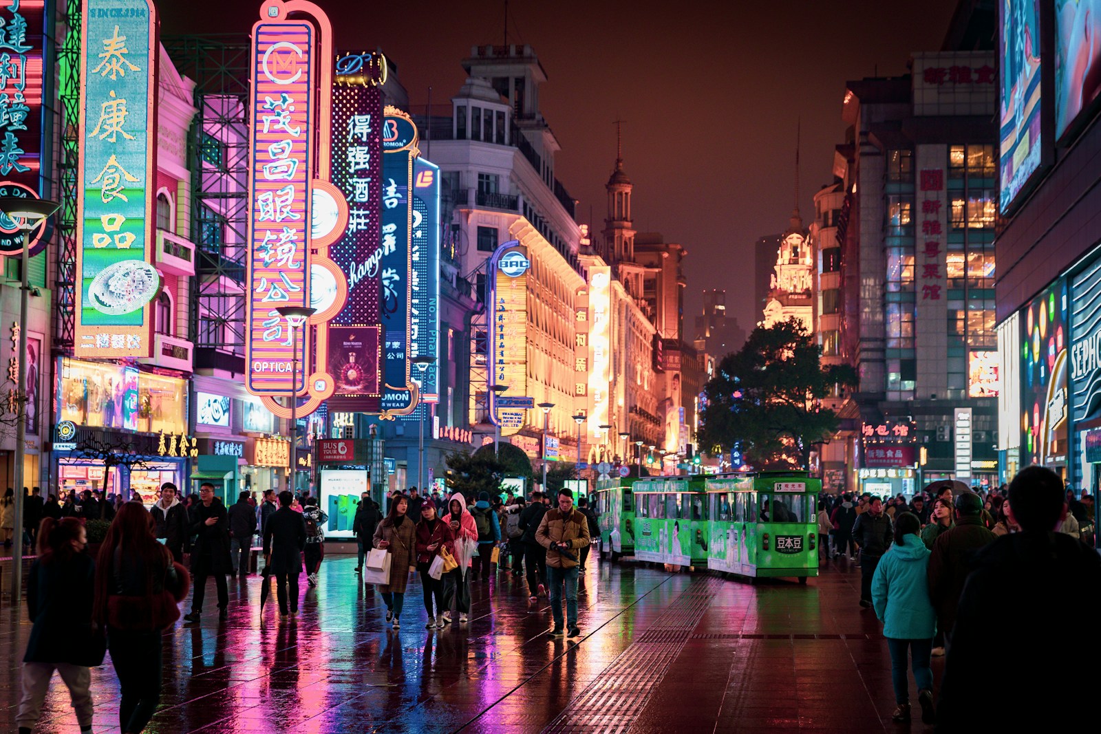 people walking and standing at the streets of the city during night